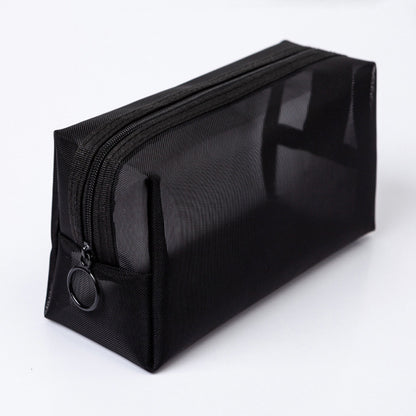 Black nylon mesh travel pouch lying diagonally on a white surface, shown on its own.