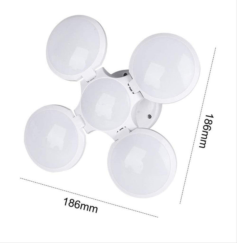 White plastic four-leaf folding LED lantern laid open on a white studio background, showing its size markings.