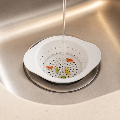 Compact white sink strainer catching small food scraps over a drain
