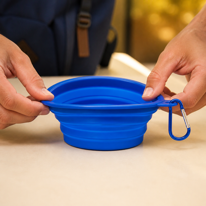 Hands expanding the blue collapsible Travel Pet Bowl