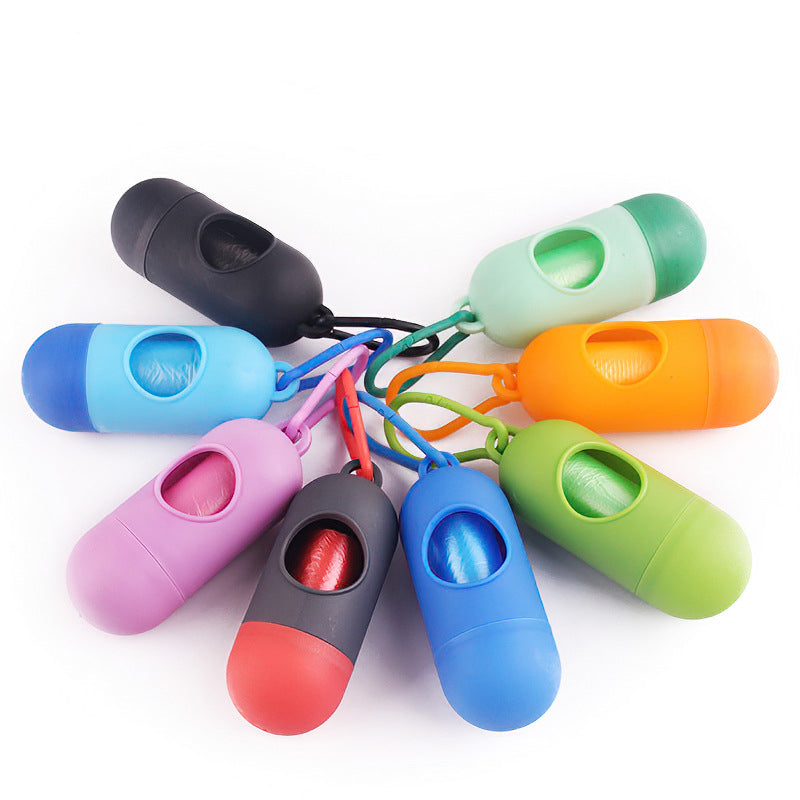 Capsule dog waste bag holders in black, light blue, purple and dark grey arranged in a circle on a white surface.