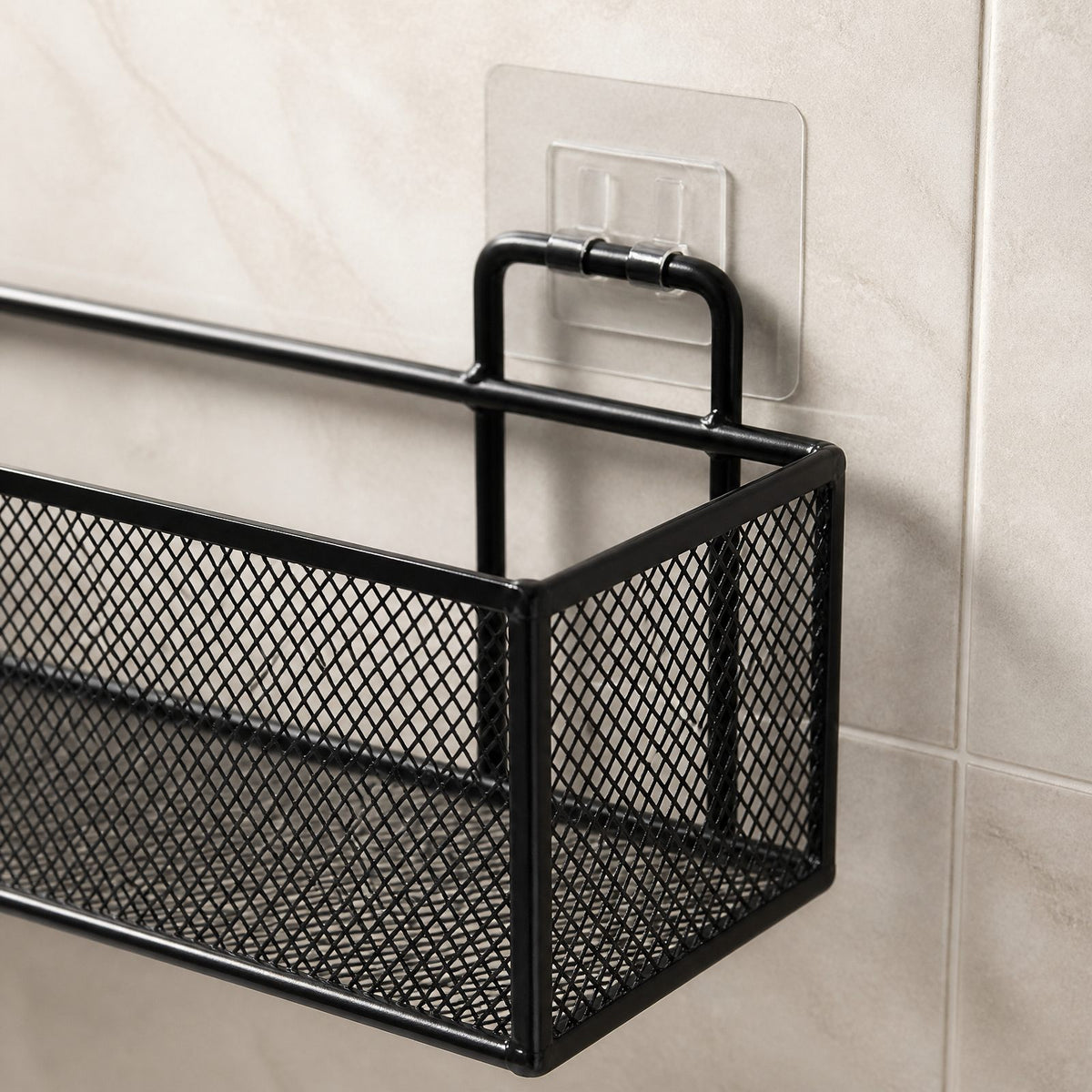 Close-up of the shower shelf's wire frame, mesh side panel and clear adhesive wall mount