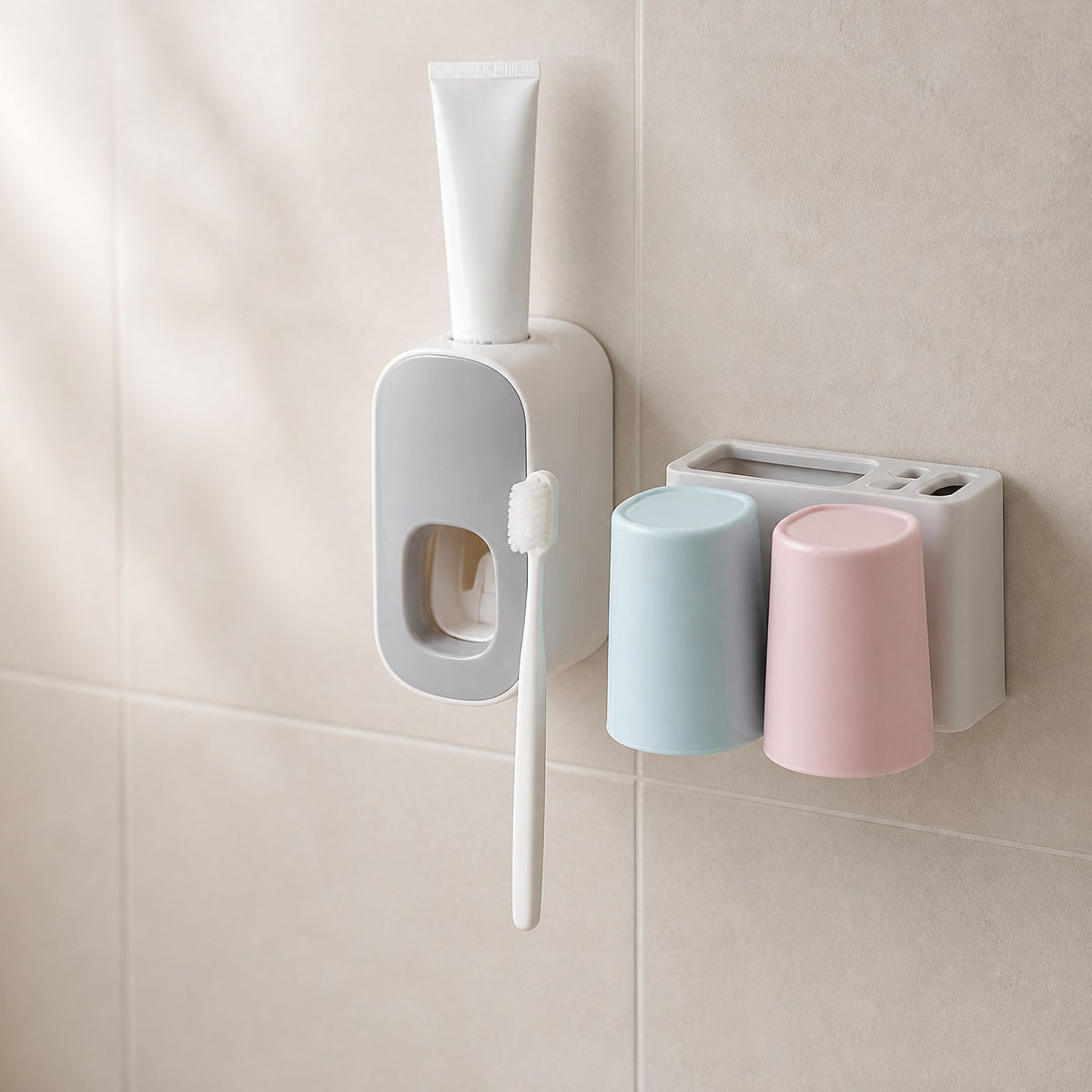 Toothbrush holder and toothpaste dispenser set mounted on a tiled bathroom wall with a blank tube and toothbrush