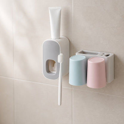 Toothbrush holder and toothpaste dispenser set mounted on a tiled bathroom wall with a blank tube and toothbrush